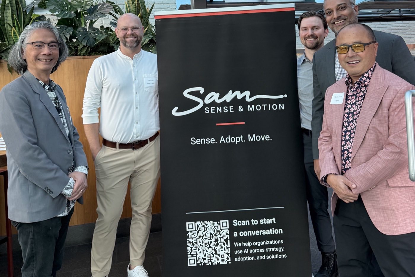 Five guests standing either side of the Sense and Motion banner