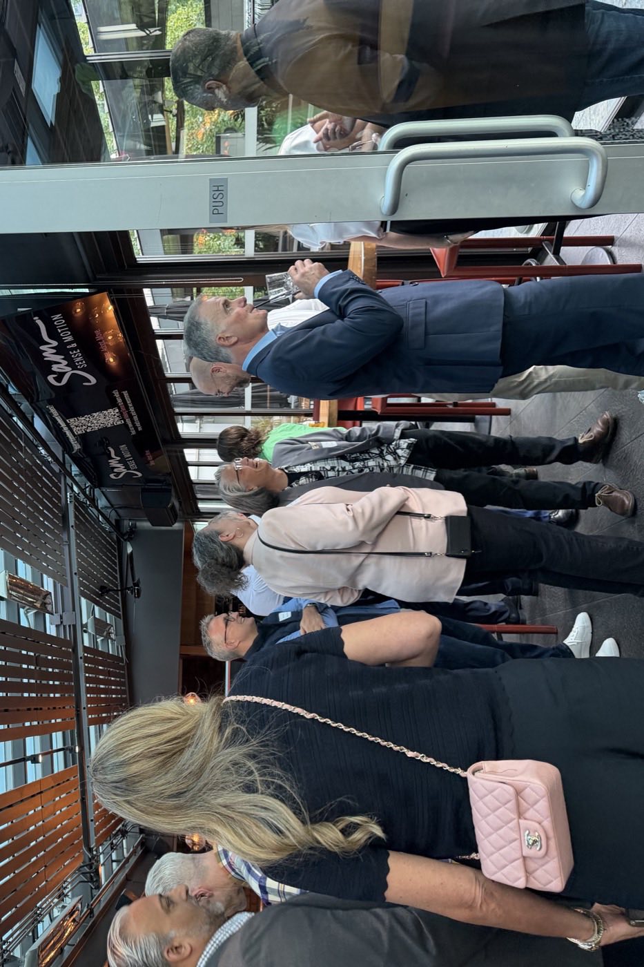 Guests standing in conversation with drinks after the formal session
