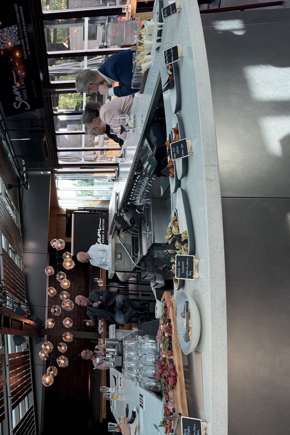 The bar at Joey&rsquo;s Burnaby laid out with canap&eacute;s, the conversation underway in the background