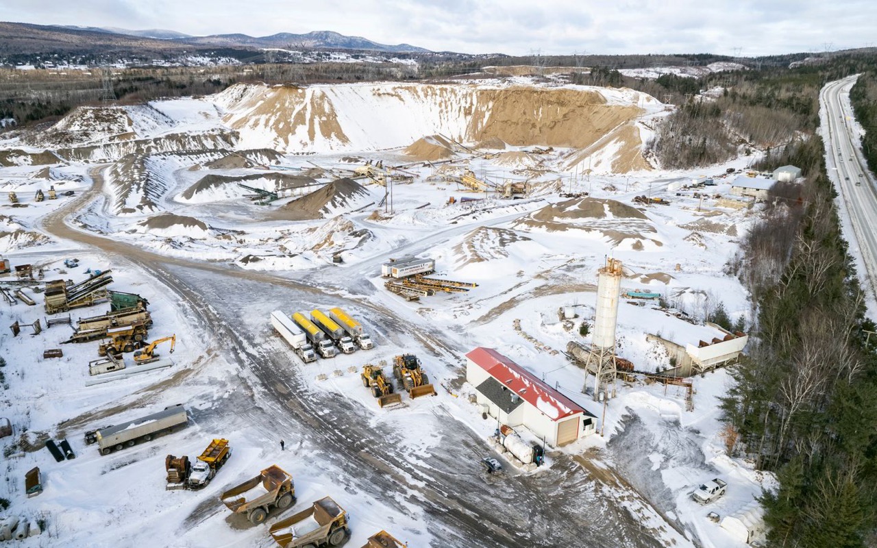 Aerial view of a snow-covered open-pit mine site in winter