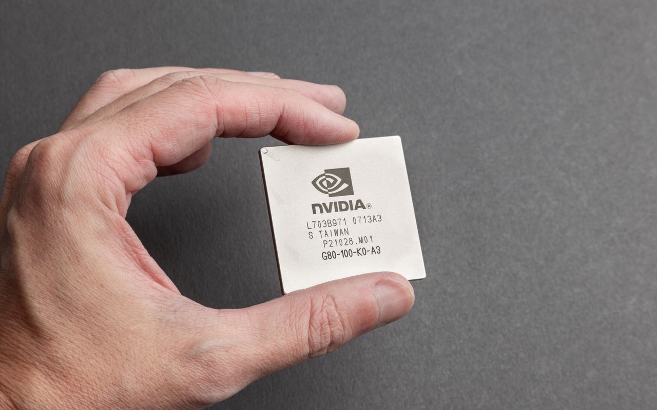 A hand holding an Nvidia graphics processing unit chip