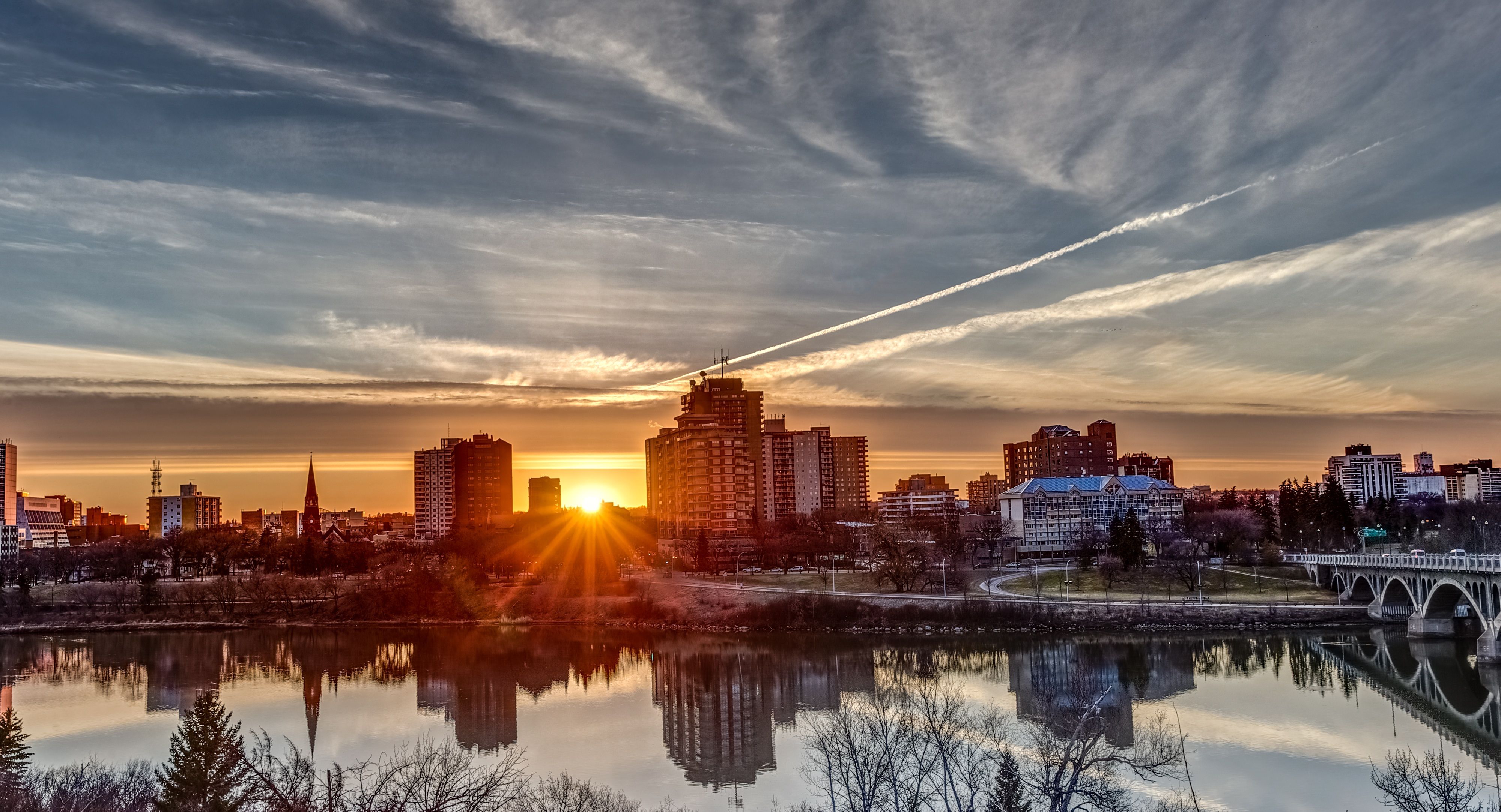 Downtown skyline at sunset reflected in the river, Saskatchewan