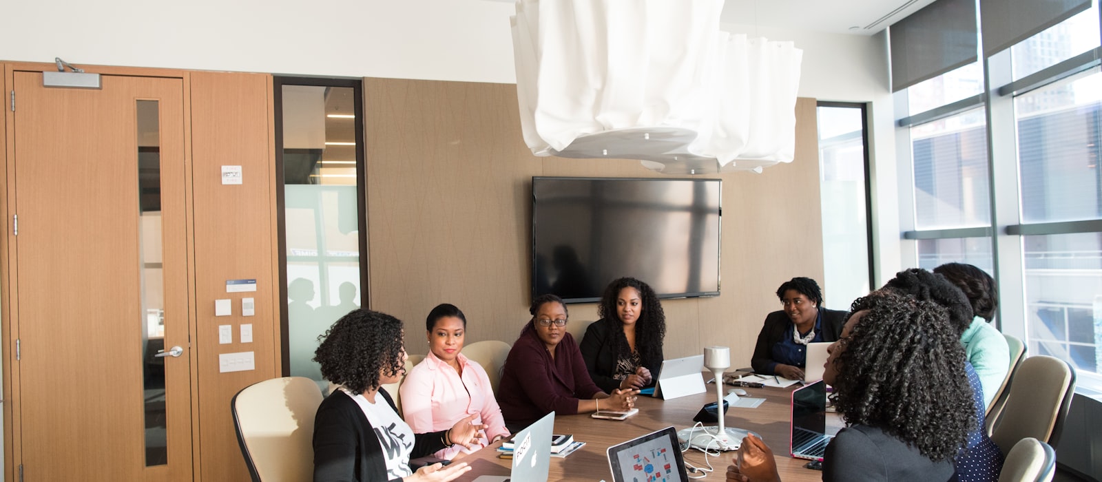 A leadership team meeting with laptops in a modern office